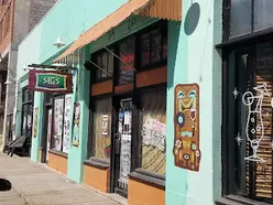 Exterior of Sig's Lagoon. There is a sign that says Sig's Lagoon next to the door.