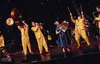 band on stage in yellow suits.